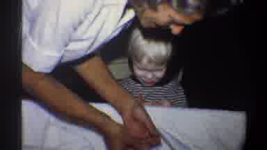 Gainsville Florida USA (1974): Child And A Baby With His Mother Tidying Up And