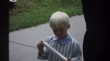 Gainsville Florida USA (1974): Boy Wearing Blue And White Shirt Looking At White