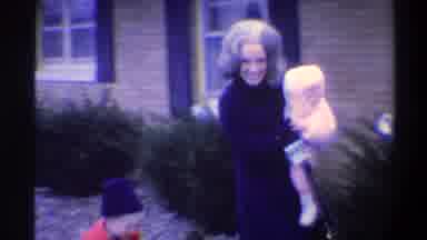 Gainsville Florida USA (1974): A Woman With A Funny Hear Carrying A Small Baby On