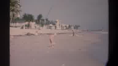 Gainsville Florida USA (1974): Boy In Red Shorts On A Wide Beach With His Pet Dog