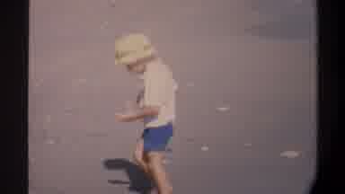 Gainsville Florida USA (1974): A Child Walking At The Beach Looking For Treasures