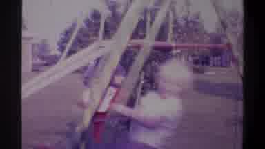 Gainsville Florida USA (1974): Two Kids Playing On A Swing Set While Their Parents