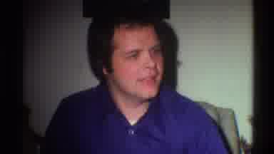 Gainsville Florida USA (1975): One Man On Blue Shirt About To Open A Present