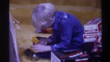 Gainsville Florida USA (1975): Boy Wearing Blue Shirt Playing With Toy On Gold