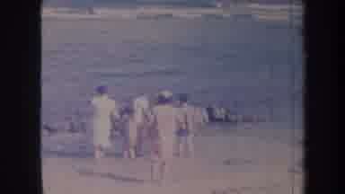 Honolulu Hawaii USA (1967): Old Woman Walking In A Beach With Other People