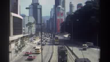 HONG KONG-1982: Downtown Traffic Near A Highway With View Of Skyscrapers
