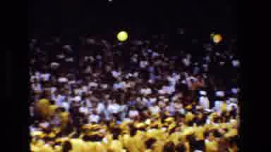 Lansing Michigan -1983: Graduation Class Throwing Caps In Air Followed By Woman