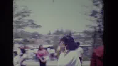 Lansing Michigan (1983): Woman Shields Face At Outdoor Gathering On Bright Sunny