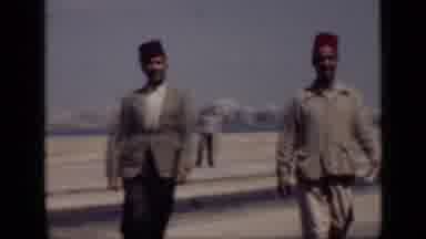 Cairo Egypt (1946): Two Men Wearing Hats Walking In A City; A Third Man In A Blue