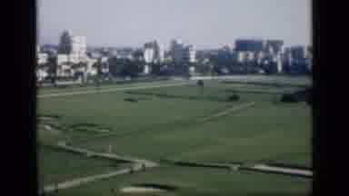 Cairo Egypt (1946): Someone Running Through A Large Field In A Busy City With Big