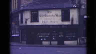 London England (1946): An Old Downtown Building And A Sign For A Church Are