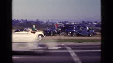 San Diego California USA (1949): Cars On Roadway In Front Of Field