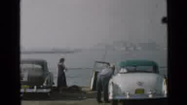 San Diego California USA (1949): Two People Fishing Next To Their Parked Cars