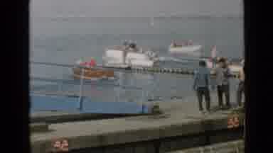 San Diego California USA (1949): People Walk On A Seawall While Small Boats Motor