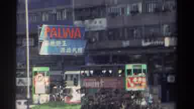 HONG KONG-1982: Shaky 8mm Footage Of Green Trams And A PALWA Sign In A Crowded City Street