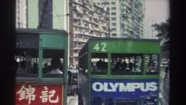 Hong Kong (1982): Green And Blue Bus With The Word Olympus On The Front Passes By
