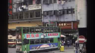 HONG KONG-1982: Green Tram Travelling Busy Street With Kaiser Ad