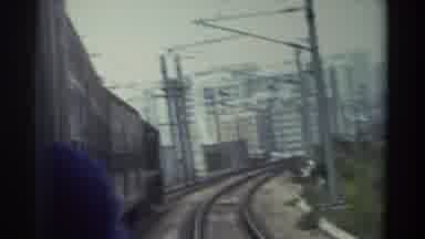 Hong Kong (1982): Light Rail Goes Down Track Passing People On The Sides In A Big