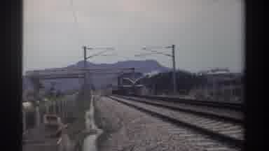 Taiwan (1982): Green And Yellow Train Moving On Tracks On A Cloudy Day