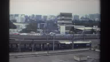 Taiwan (1982): Long Train Passes Underneath A Interstate Bridge Beside Businesses