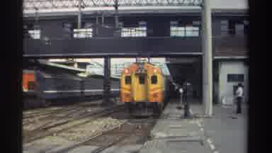 Taiwan (1982): Orange And Yellow Train Leaves Station And Rolls Down Railroad