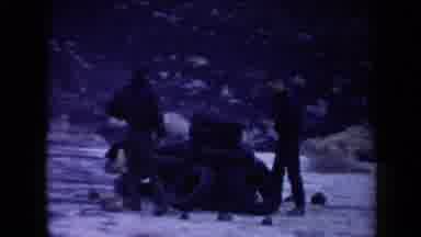 Arizona USA (1958): Men Attempting To Start Fire Using Rubber Tires On Clear