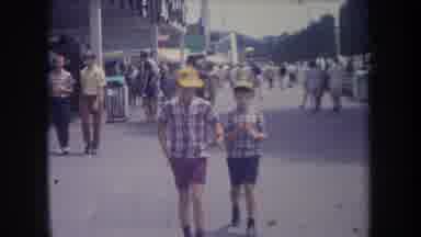 Michigan USA-1968: Two Boys With Caps Walking Fast In A Crowded Street Of The