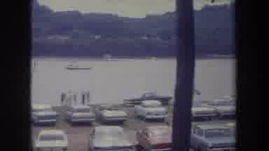 Michigan USA (1968): River Shore Has Been Parked Full Of Cars And A Boat Is Going
