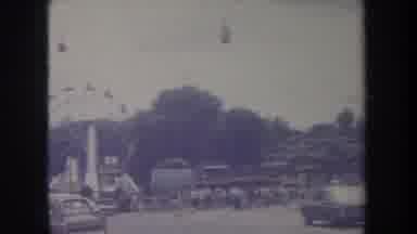 Michigan USA (1968): People Attend An Amusement Park With A Roller Coaster And