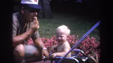 Michigan USA (1968): Child Crying In A Swing On Road Side And A Man Eating Ice