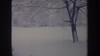 Michigan USA (1968): An Old Car Moving Among Trees On A Road Covered With White