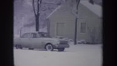 Michigan USA (1968): Old Car Slowly Drives Through The Snow In Black And White