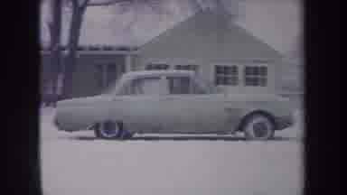 MICHIGAN USA-1968: Classic Car Driving Through Snowy Suburban Yard