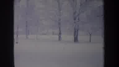 Michigan USA (1968): A Car Drives Along A Snow Covered Road With Trees In The