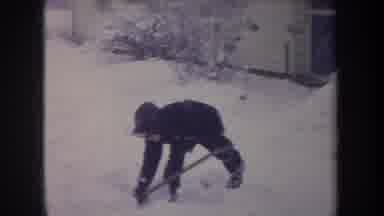 Michigan USA (1968): Boy In Winter Clothing Shoves Snow From One Point To Another