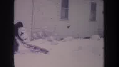 Michigan USA (1968): Child Bundled Up In Winter Getting His Tabogon Ready To Go