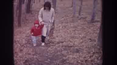 Michigan USA (1968): Mother Walks A Toddler Along A Forest Trail In Winter With