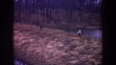 Michigan USA (1968): Two People Strolling Through The Grass Next To A Pond In The