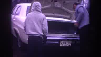 Michigan USA (1968): In This Video We See Men Looking At The Trunk Of A Car And