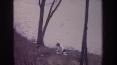 Michigan USA (1968): Man Digging Earth On The Edge Of A Lake From Below A Very