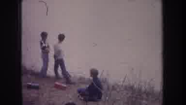 Michigan USA (1968): Three Boys Outside Fishing Near A Shallow River On Sitting