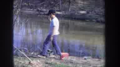 Michigan USA (1968): Boy Reels In A Fish From A Fishing Line Set On The Short Of A