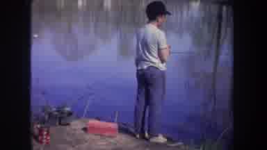 Michigan USA (1968): Young Boy Fishes At A Pond And Catches A Fish