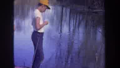 Michigan USA (1968): Man With Yellow Ball Cap Throwing Object Into River
