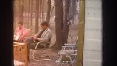 Michigan USA (1968): Man And Woman Sitting At Campground Near Baby Crib With Young