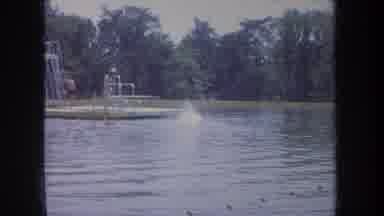 Michigan USA (1968): Swimmer Jumps Off Of A Diving Board On A Floating Platform