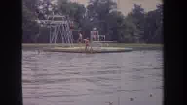 Michigan USA (1968): People In Bathing Suits On A Platform On Side Of Lake Diving