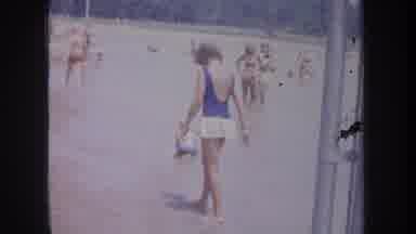 Michigan USA (1968): In The Beach Setup With Many Women In Bikinis A Kid Playing