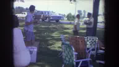 Michigan USA (1968): Man And Boy Hold Sign At Large Picnic On A Sunny Day
