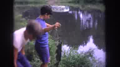 Michigan USA (1968): Two Young Boys With A Small Fish They Caught On A Line At A
